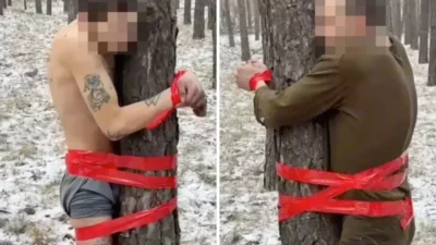 Donmuş ormanın ortasında, neredeyse çıplak halde ağaca bantlanmış iki Rus